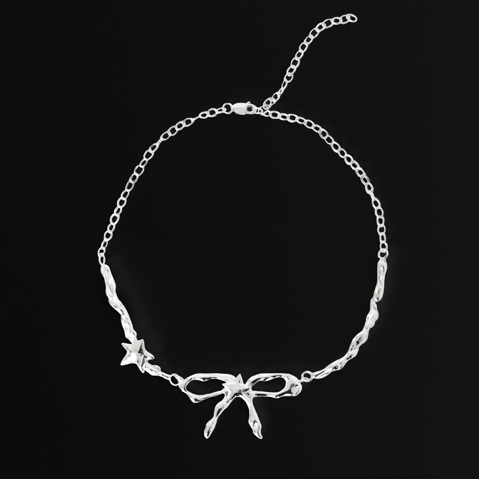 Silver necklace with bow design on a black background
